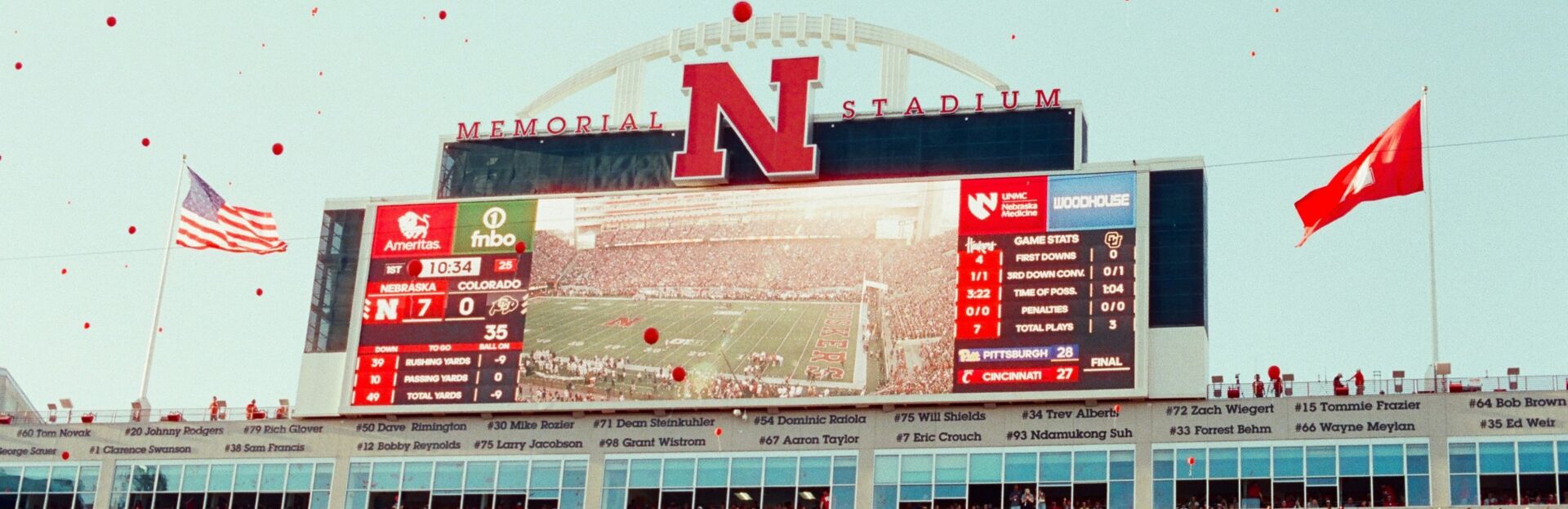 College football stadium scoreboard above a packed crowd